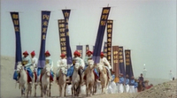 Soldiers on horseback carry tall banners with writing on them.