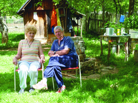 A portrait of a Bosnian man and woman sitting in a chair in outside.
