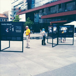 In the middle of an outdoor square in Sarajevo, people look at a photo exhibit.