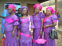 Four women wearing pink and purple aso ebi.