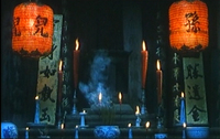 An altar is surrounded by banners and lanterns with black calligraphy.