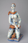 Large-­scale garden sculpture of a woman kneeling, decorated with bright orange and blue glazes.