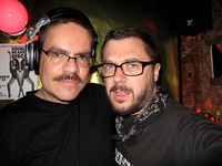 Disco Connie, in a moustache and wearing DJ headphones, in a selfie with Jeff Jackson, who has a moustache and tight beard.