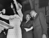 Dr. Martin Luther King Jr. and the Rev. Kelly Miller Smith confer as an unknown singer performs at Fisk University in Nashville on April 21, 1960.