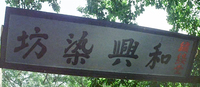 A public placard has red and black calligraphy printed on it.