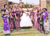Women dressed in aso ebi gathered around a bride.
