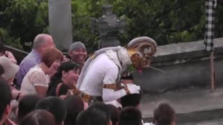 An actor in a monkey mask stands among the tourists as the chanting continues.