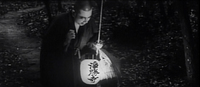 A man holds a lantern decorated with calligraphy.