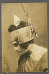 Profile photograph of Alisa Koonen in the role of Phaedra, her eyes cast downward, wearing a flat, angular headdress.