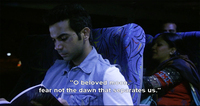 Medium shot of Deepu Sebastian (Rajkummar Rao) reading from Siras’s book of poetry, while on a bus ride at night in Aligarh. The closed caption at the bottom reads “O Beloved Moon, fear not the dawn that separates us.”