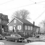 Black and white photograph of Germantown Mennonite Church and cemetery wih parked cars on street.