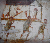 One panel of fresco. Three figures (and part of a fourth) carry a litter on their shoulders; each wears a short tunic and leans on a cane. The litter is in the form of a temple with a pediment and is decorated with greenery. Within the temple, three figures perform acts of carpentry while at the extreme left the shield of Minerva is visible and at the right one figure, interpreted as Daedalus, looks down on another figure, interpreted as Perdix, lying on his back.