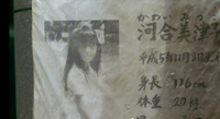 Close-up image of a photograph of a person on a poster with calligraphy to the right.