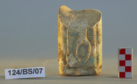 Fig 94a: Pillar of Egyptian faience with was scepter, front (94a) and back (94b). The two prongs and the lowest part of the staff are shown. The faience pillar measures 6.1 cm high by 3.7 cm wide.