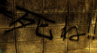 Black graffiti for "Die!" is written on a beige cement brick wall.