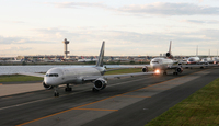 Jet planes sitting one behind another waiting for their turn to take off.