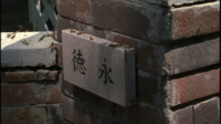 Calligraphic plates against a brick post.