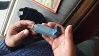 Ashtma inhaler held in the palm of Ed Garcia Conde's hand.