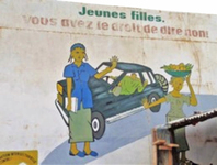 In a piece of artwork, a man driving a car leans out of his car window to gesture to a girl carrying fruit on her head along the road. A woman standing next to the car puts her hand up as if to push the girl away, and the girl does the same in the direction of the car. At the top of the artwork, “Young girls, you have the right to say no!” is written in French.