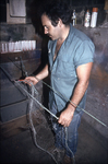 Full body photograph (from side) of John Verissimo mending gill net.