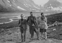 Robert Herring, Kenneth Macpherson and Bryher stand together in front of mountains.