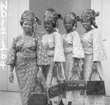 A group of four standing women wearing aso ebi.