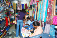 Seated women reading fashion magazines inside Ifeyinwa Oguchi’s Textile Shop.