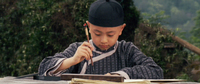 A boy paints calligraphy.