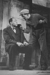 Black and white publicity photo of Frank Wilson as Joe and Paul Robeson as Jim Harris in the 1924 production of O’Neill’s All God’s Chillun Got Wings. Robeson is sitting, while Wilson stands next to him with his fist clenched.