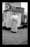 Black and white photograph of a woman standing on the roof of a tenement.