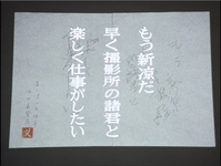 A piece of paper with writing sits on a black background; the writing is messy, witht the columns overlapping in places. In the tradition of Buddhist disciples capturing the moment of death of their master through calligraphy on the page, the great director Mizoguchi Kenji wrote this on his death bed for his staff: "The chill autumn air has already arrived. I want the pleasure of working with all of you at the studio." On the lower left above the seal it says, "Mizoguchi Kenji's last writing (_zeppitsu_); recorded by Yoda Yoshikata." The seal has the crushed character for 義, the third character in Yoda's name. The writing is nearly illegible, so white typographic characters are superimposed over the image.