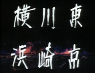 White calligraphy is superimposed over a series of explosions in a residential district, listing the names of Tokyo, Kawasaki and Yokohama.