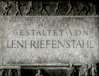 German director credit text is carved into stone, in black and white cinematography.