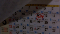 A red "marriage" is circled in a heart written on a calendar, probably written with a red magic marker. The main character looks at this reminder every day.