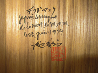 Detail photograph of a wooden box interior with black calligraphy and red seal.