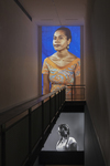 Color photograph of an art installation showing two cinematic portraits, one of a Fijian woman and one of an African American woman.