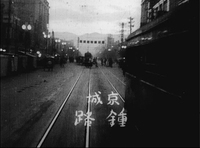 Intertitle, time and place in Japanese, white handwriting at the bottom of the scene, written horizontally from right to left
