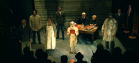 This is a picture of multiple actors on stage at the end of the play ‘Coranderrk: We Will Show the Country,’ with Uncle Jack Charles (playing William Barak) reading the petition.