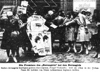 A group of women in coats in front of a newspaper stand.