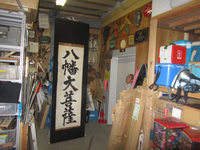 Photograph of a tall calligraphy scroll in storage.