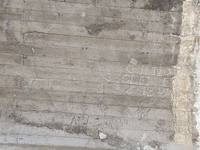 Fig. 29. On a crumbling, water-­stained concrete wall in Los Angeles, chalk and charcoal markings seem to indicate directions of travel and display hobo monikers and illustrations.