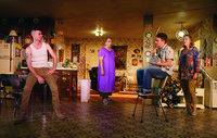 Actors Cameron Scoggins, Daniel Oreskes, Tom Phelan, and Kristine Nielsen performing in a set that looks like a suburban house, in a production of the play Hir.
