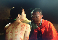 A monk paints a sutra on the body of a woman.