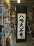 Photograph of a tall calligraphy scroll in storage.