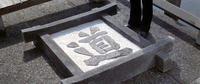 A stone block with carved calligraphy on the ground.