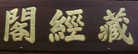 Gold calligraphy on a wooden board.