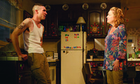 Actors Cameron Scoggins and Kristine Nielsen standing next to a refrigerator with colorful alphabet magnets in a production of the play Hir.