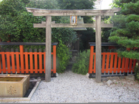 Photograph of wooden torii with worn wooden sign.