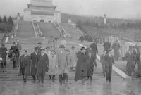 This blurred photo is yellowish, showing a number of civilian men in top hats and winter coats, followed on the right by four rows of uniformed guards in the distance, walking down a mountain lined by hundreds of stone stairs. Wang, walking in the middle at the very front, is wearing a gray coat over white shirt, tie, and dark pants. His eyes to the ground, he looks beaten and sorrowful. To his right is Chu Minyi, wrapping his dark fur-­lined coat around his body tightly, his face squeezed together, as if having bitten into a sour lemon. The bespectacled Zhou Fohai, walking behind them, is, however, laughing with another man walking by his side. Other people are alternatively looking joyous, anxious, or tense.