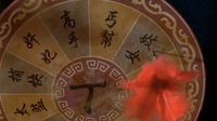 A red plumed dart lands in a circular board, with black calligraphy.